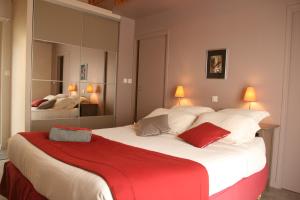- une chambre avec un grand lit et une couverture rouge dans l'établissement Le Clos Pen Kear, à Plouarzel