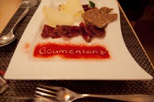 een bord met kaas en vlees op tafel bij Ski-In/Ski-Out Hotel Sport in Saas-Almagell