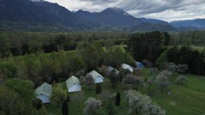 un grupo de casas en un campo con árboles y montañas en Mavidahue, en llifen