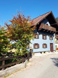 Biały dom z drewnianym płotem i drzewem w obiekcie Ferienhaus Alpenglück w mieście Gaicht