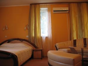 a bedroom with a bed and a chair and a window at Premier Club in Chernivtsi