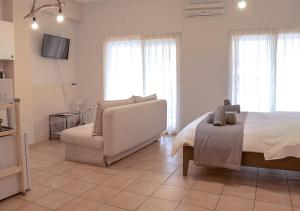 アテネにあるAthens Modern Minimalistic Sunny Studio With Balconyのベッドルーム1室(ベッド1台、ソファ、椅子付)