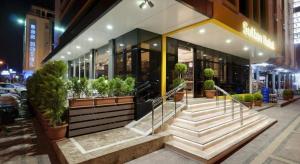 a building with a bunch of potted plants outside of it at Sultan Hotel in Mersin