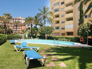 a swimming pool with two lounge chairs and a building at urbanización puerto paraiso in Estepona