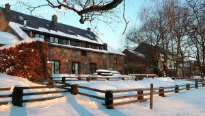 a house with a fence in the snow at Vennhaus 33 pers in Waimes