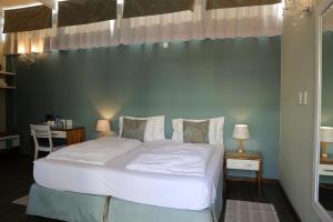 1 dormitorio con cama blanca y pared azul en Namib Guesthouse en Swakopmund