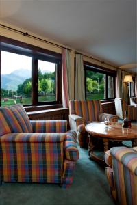 a living room with couches and a table and windows at Parador de Fuente Dé in Fuente Dé