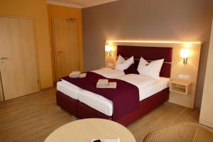 Bad KleinenにあるSeehotel Bad Kleinenの大きなベッドとテーブル2台が備わるホテルルームです。