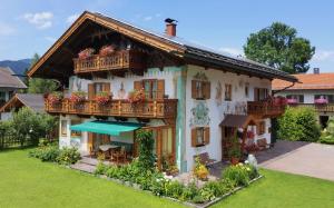 uma casa com uma varanda com flores em Feriendomizil St. Ulrich em Krün