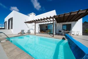 a villa with a swimming pool and a house at El Tucan, excelentes vistas y privacidad in Nazaret