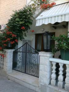 蒂瓦特的住宿－Romana 1，一座带黑色铁门和鲜花的房子