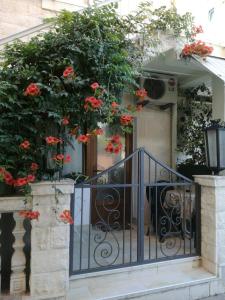 a house with a gate with red flowers on it at Romana 1 in Tivat
