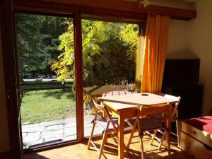 a table and chairs in front of a sliding glass door at studio isabelle in Saint-Chaffrey