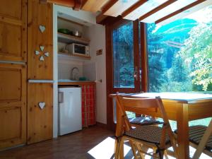 a kitchen with a table and a refrigerator and a window at studio isabelle in Saint-Chaffrey