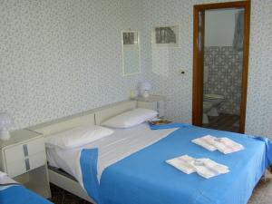 a bedroom with a blue bed and a mirror at Baia del Sole in Paestum