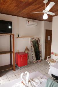 Habitación con cama, TV y espejo. en Pousada do Carlos, en Arraial d'Ajuda