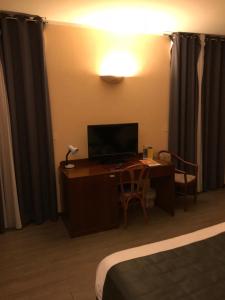 Televiisor ja/või meelelahutuskeskus majutusasutuses Hôtel Vesuvio