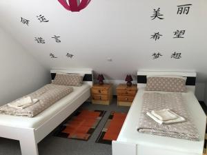 two beds in a room with asian writing on the wall at Ferienwohnung Aretsried 2 in Fischach