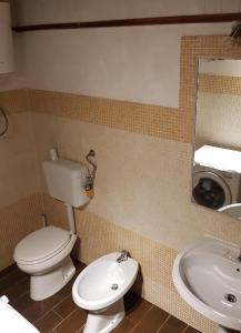 uma casa de banho com um WC, um lavatório e um espelho. em Le Antiche Mura em Sassari