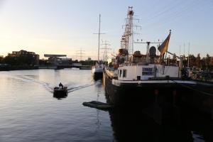汉堡Schiffshotel "Schlafen im Hafen"的两艘船停靠在码头旁边的水中