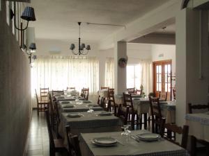 a dining room with long tables and chairs in a restaurant at "O Viajante" Low Cost Hotel in Estremoz