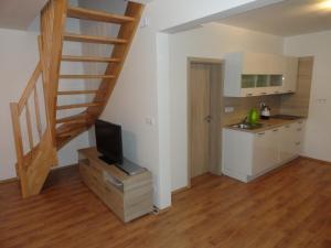 a living room with a staircase and a kitchen at Chata Karamelka in Dolní Moravice