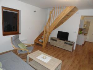 a living room with a couch and a tv and stairs at Chata Karamelka in Dolní Moravice