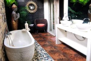 a bathroom with two sinks and a bath tub at Bamboo Moon Villas in Sanur