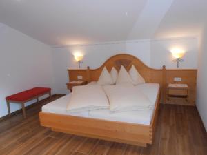 um quarto com uma cama com almofadas brancas em Gollehenhof em Sankt Johann im Pongau