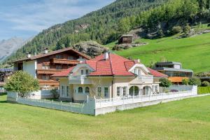 dom z czerwonym dachem na wzgórzu w obiekcie Villa Castelbell w Solden