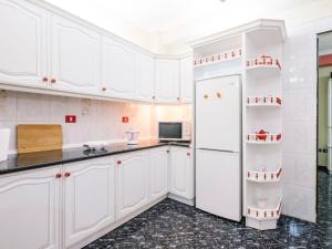 サンタクルス・デ・テネリフェにあるApartamento Centricoのキッチン(白いキャビネット、白い冷蔵庫付)