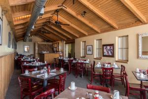 a dining room with tables and chairs and wooden ceilings at Landmark Lookout Lodge in Tombstone