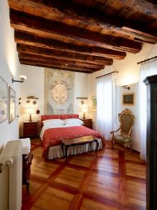a bedroom with a large bed and wooden floors at Palazzo Morosini Brandolin Dimora Romantica in Venice