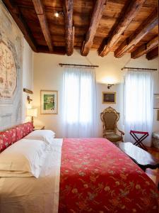 - une chambre avec un grand lit et une couverture rouge dans l'établissement Palazzo Morosini Brandolin Dimora Romantica, à Venise