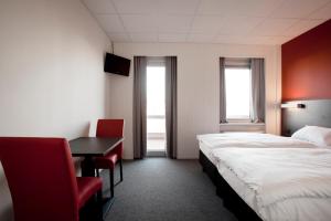 a hotel room with a bed and a table and chairs at Antwerp Harbour Hotel in Antwerp +37 photos