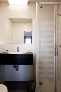 a bathroom with a sink and a toilet and a mirror at Antwerp Harbour Hotel in Antwerp