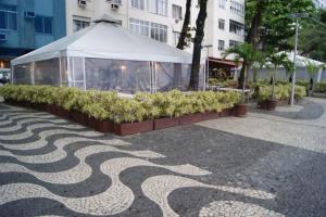 Tienda blanca con plantas en una acera en xxxxxxxxxxxxxxxx, en Río de Janeiro