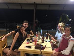un gruppo di persone seduti a un tavolo con bevande di Lake Vision Guesthouse a Pokhara