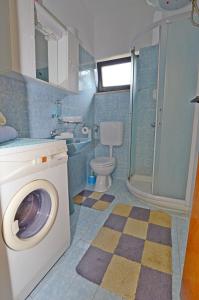 a bathroom with a washing machine and a toilet at Apartment Velimir in Poreč