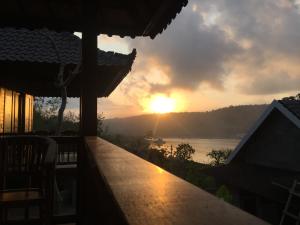 uma vista para o pôr-do-sol a partir de uma varanda de uma casa em Sunday Huts Lembongan em Nusa Lembongan
