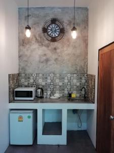 uma cozinha com um balcão com um lavatório e um micro-ondas em Baan Minnie em Ko Samed