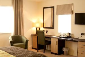 a hotel room with a desk and a mirror at The Craven Heifer Inn in Kelbrook