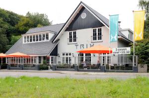 een wit gebouw met oranje paraplu's ervoor bij Hotel Trix in Arnhem