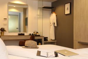 莱卡邦素万那普机场奇迹酒店的挂在床上的帽子和镜子