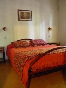 1 dormitorio con 1 cama con sábanas y almohadas rojas en Cabañas Ranquil Luncay en Uspallata