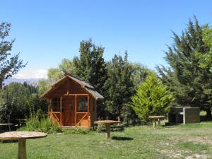 une petite cabane en bois dans un champ arboré dans l'établissement Cabañas Ranquil Luncay, à Uspallata