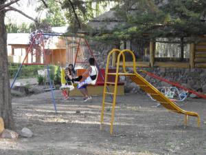 ウスパジャタにあるCabañas Ranquil Luncayの遊び場のブランコで遊ぶ子供2名
