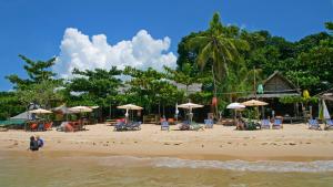 a beach with chairs and umbrellas and people on it at Sea Culture in Ko Lanta