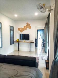 a living room with a couch and a flat screen tv at ComeHome Lamphun in Lamphun