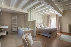 - une chambre avec un lit, une baignoire et un lavabo dans l'établissement La Barbotiere, à Chevannes